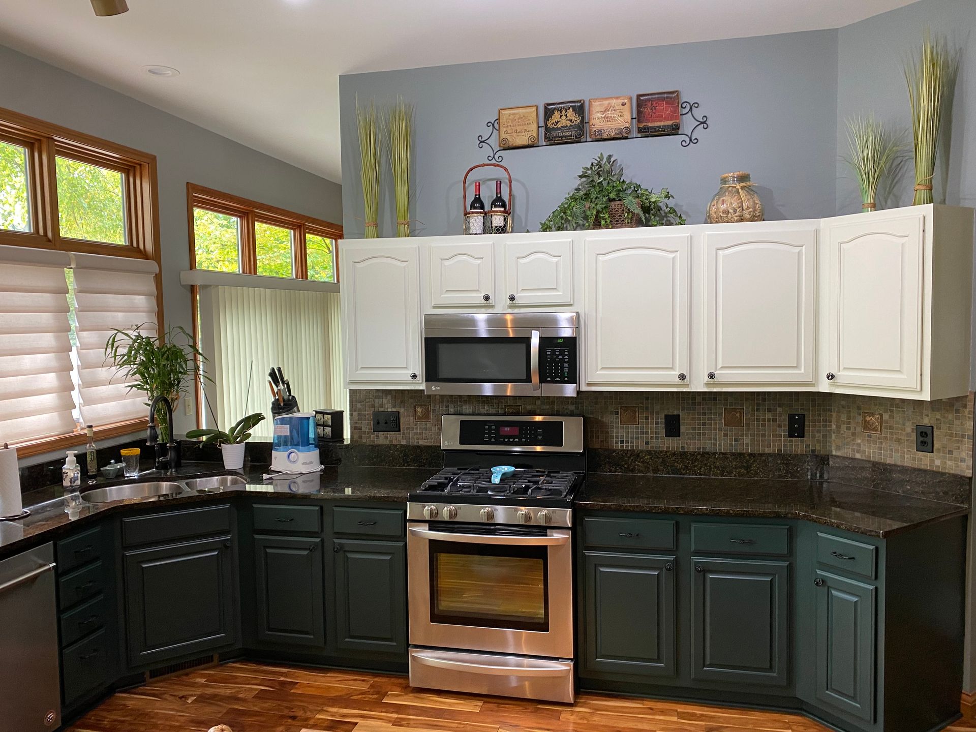 A kitchen with green cabinets and stainless steel appliances