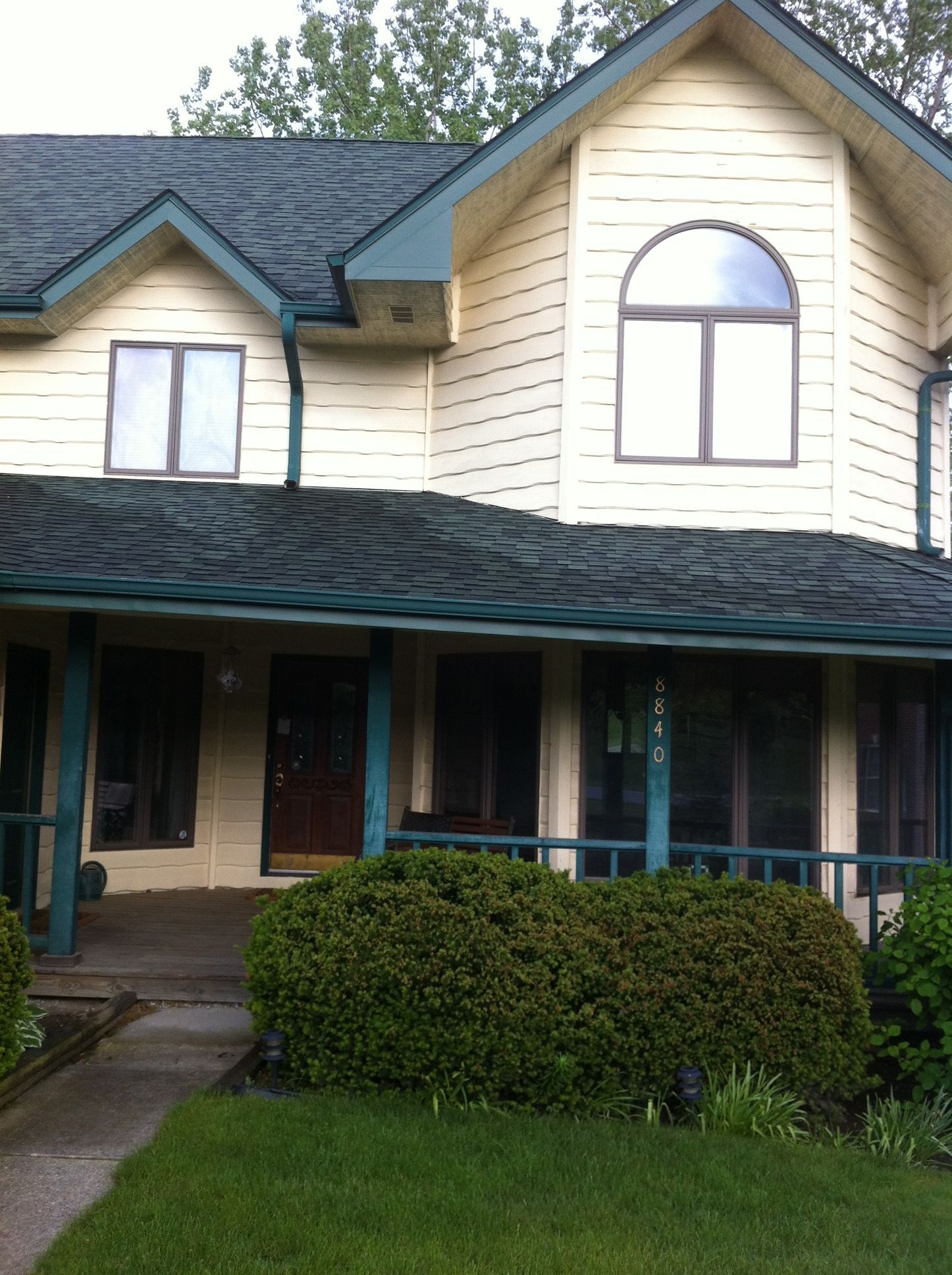 A white house with a blue roof and a porch