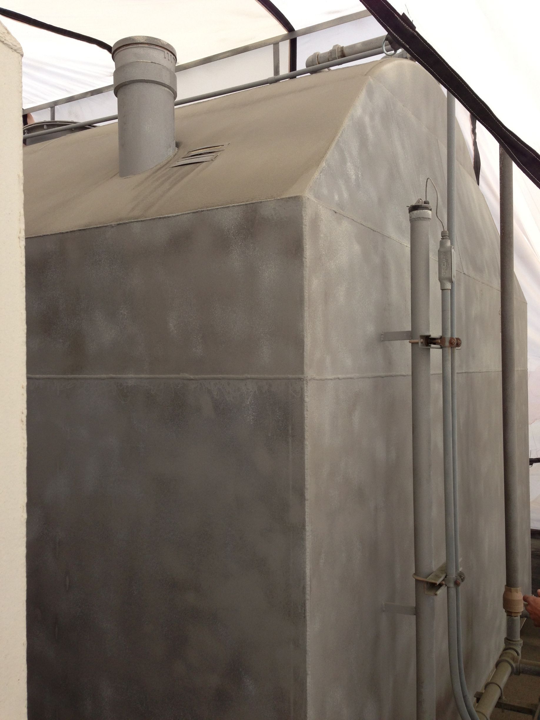 A large gray building with pipes coming out of it