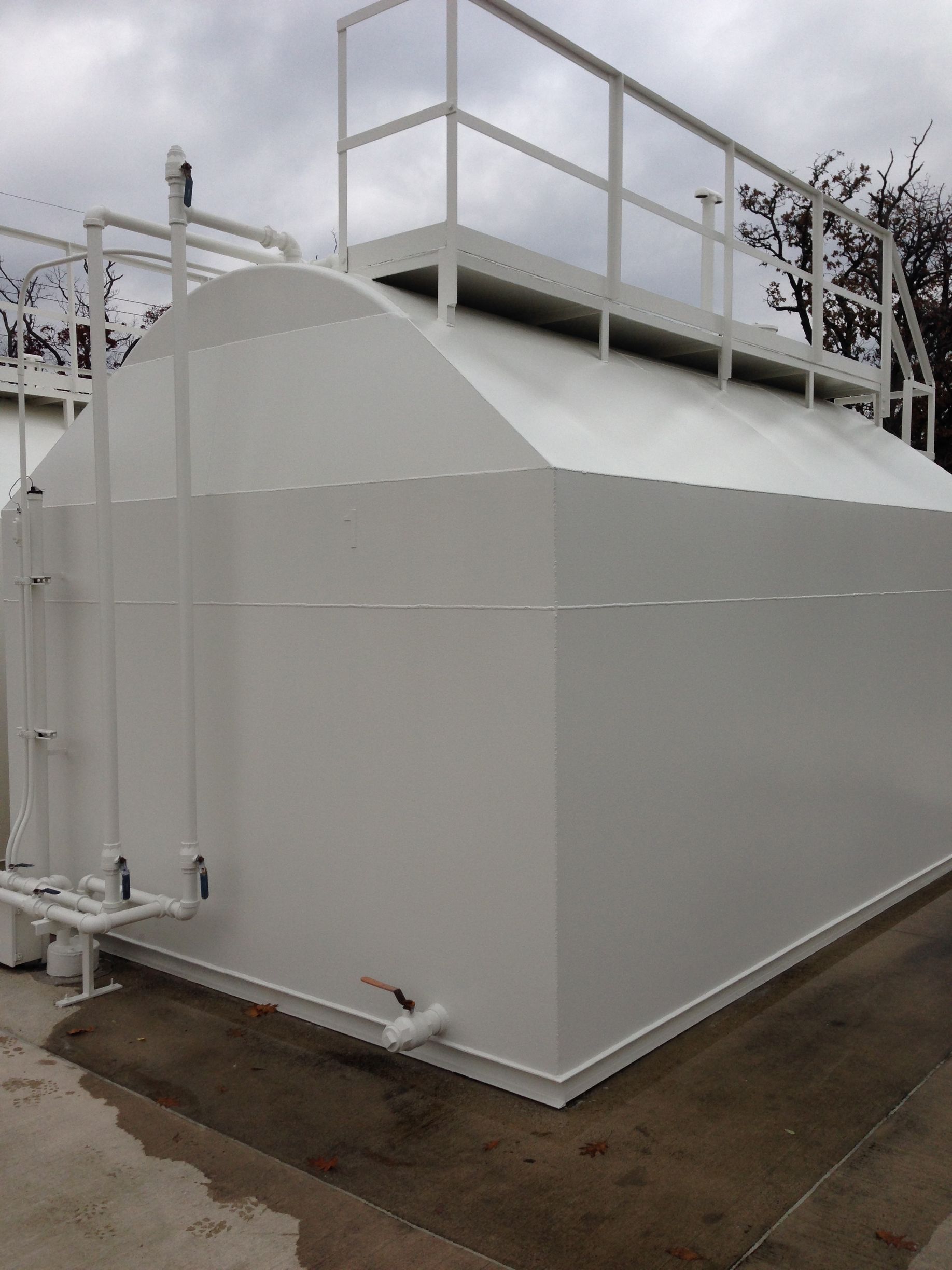 A large white tank with a railing on top of it.