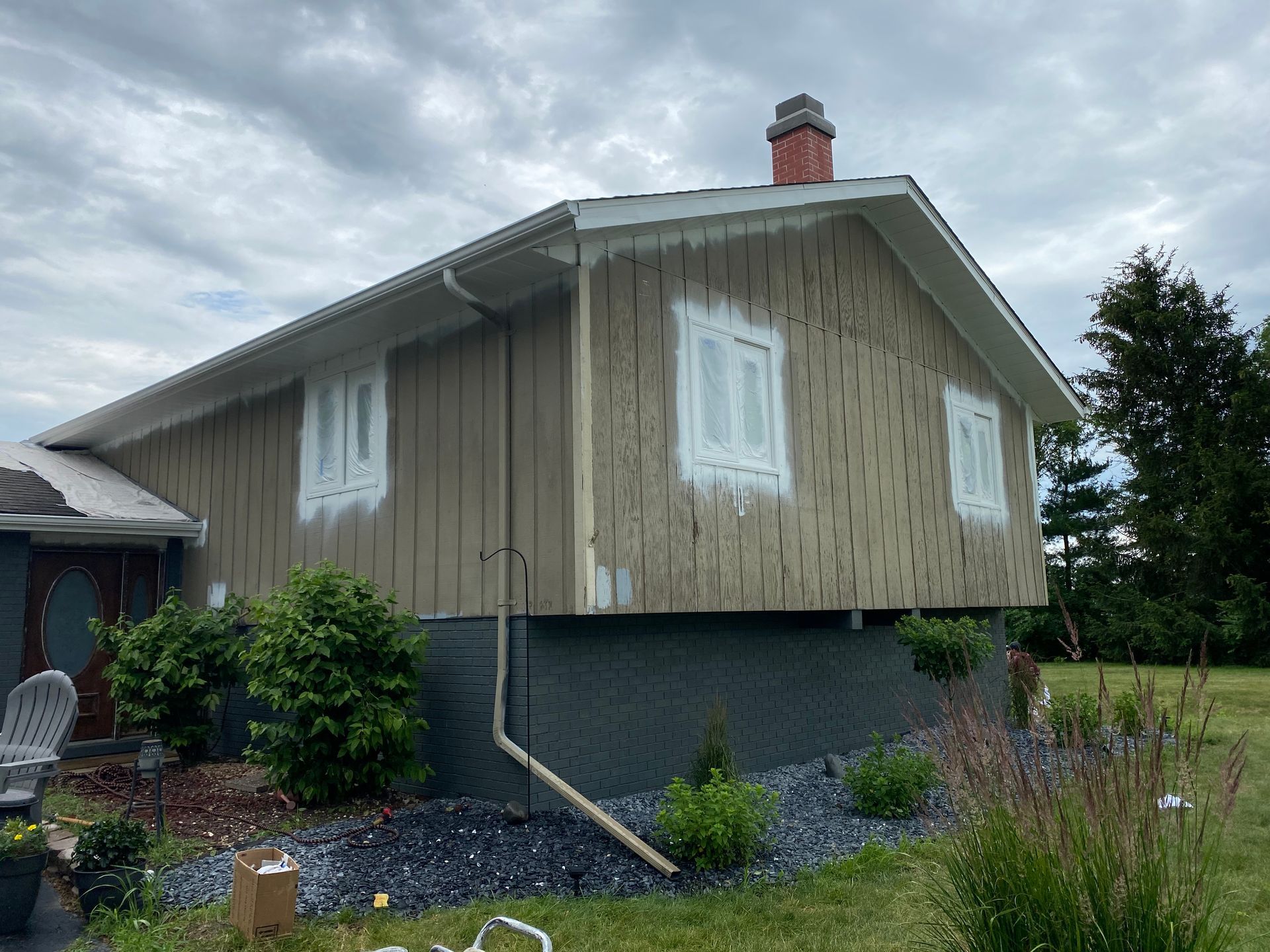 The side of a house is being painted white.
