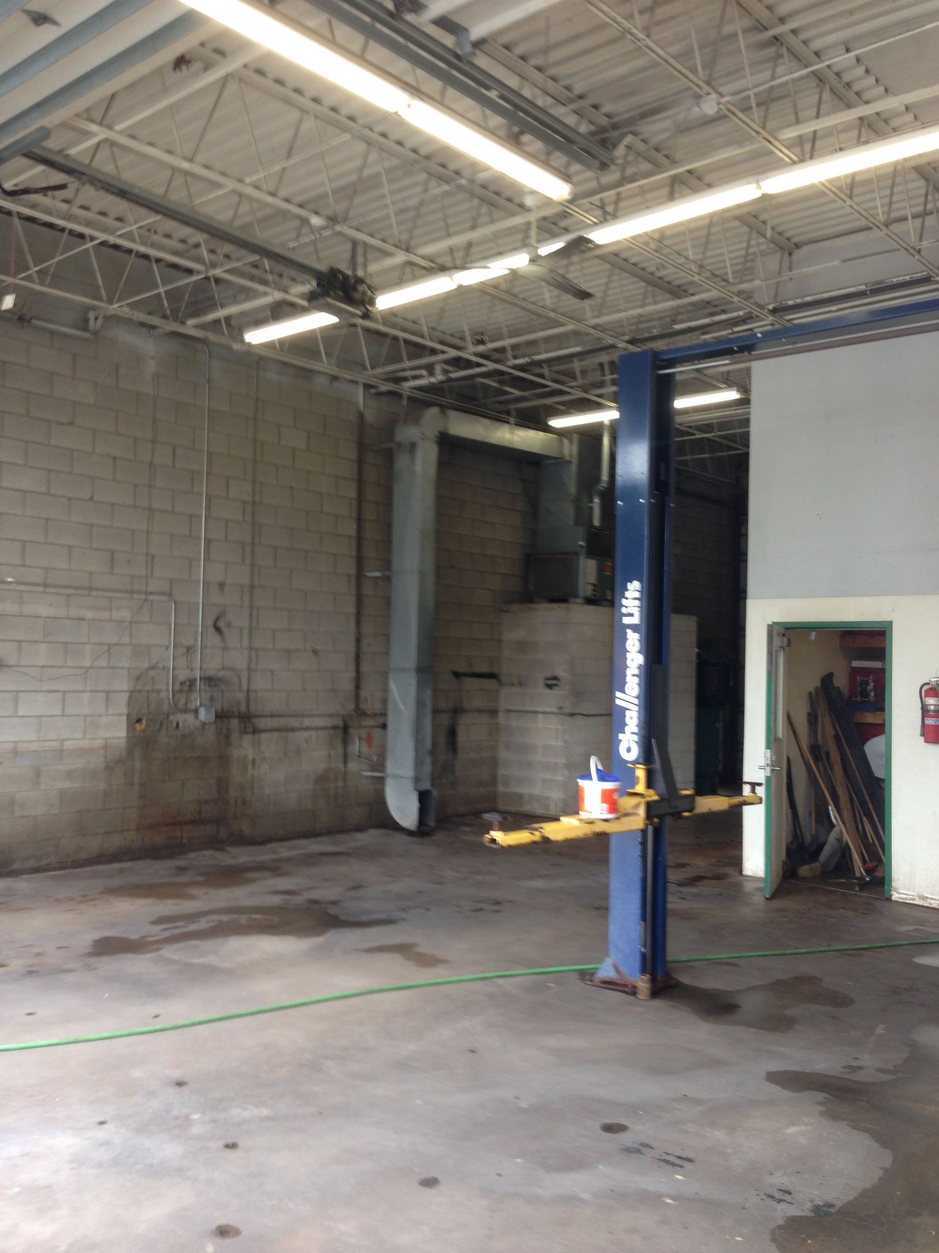 An empty garage with a blue pole that says challenge lift on it