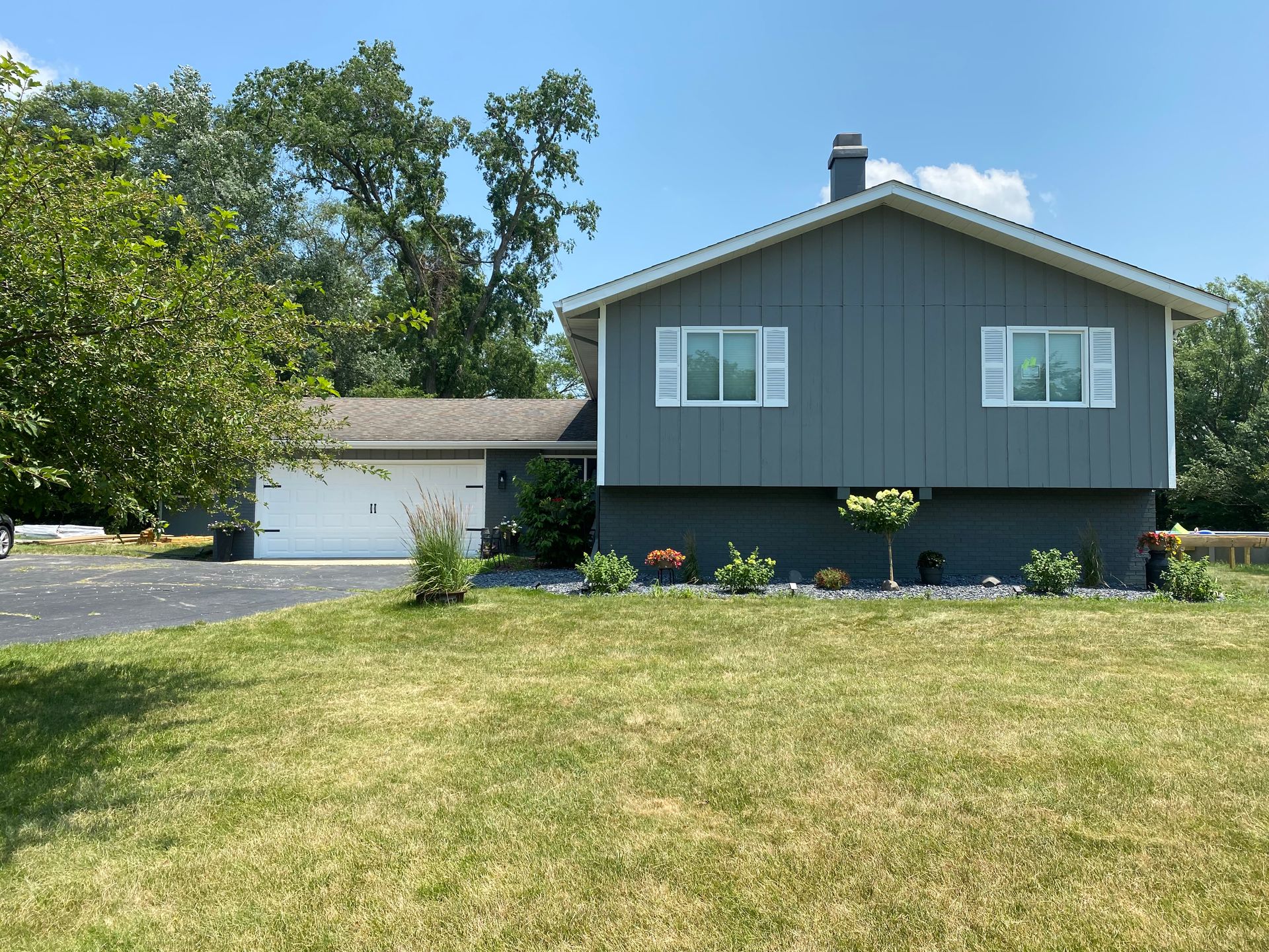 A house with a large lawn in front of it and a garage.
