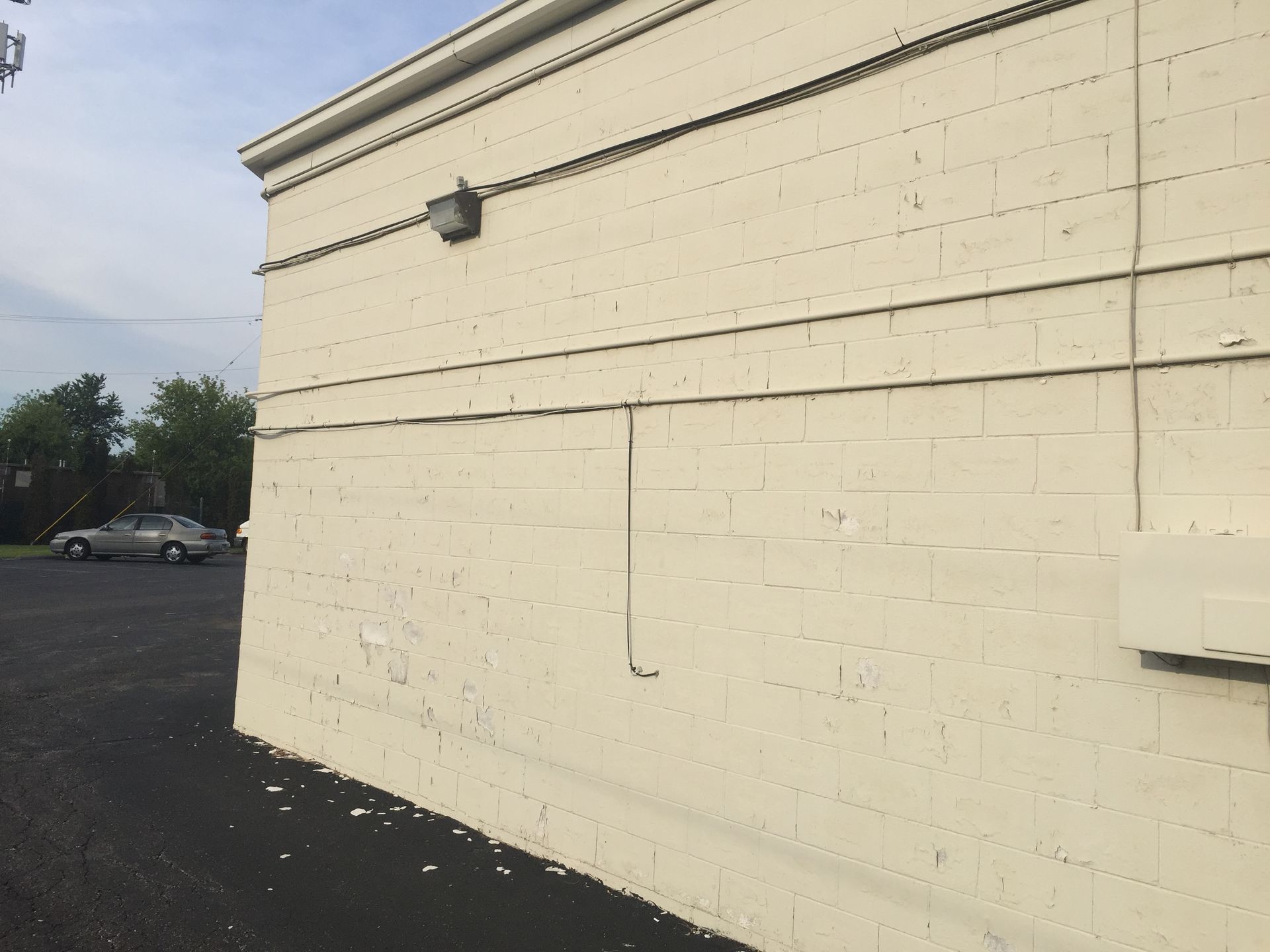 A white brick building with a parking lot in front of it