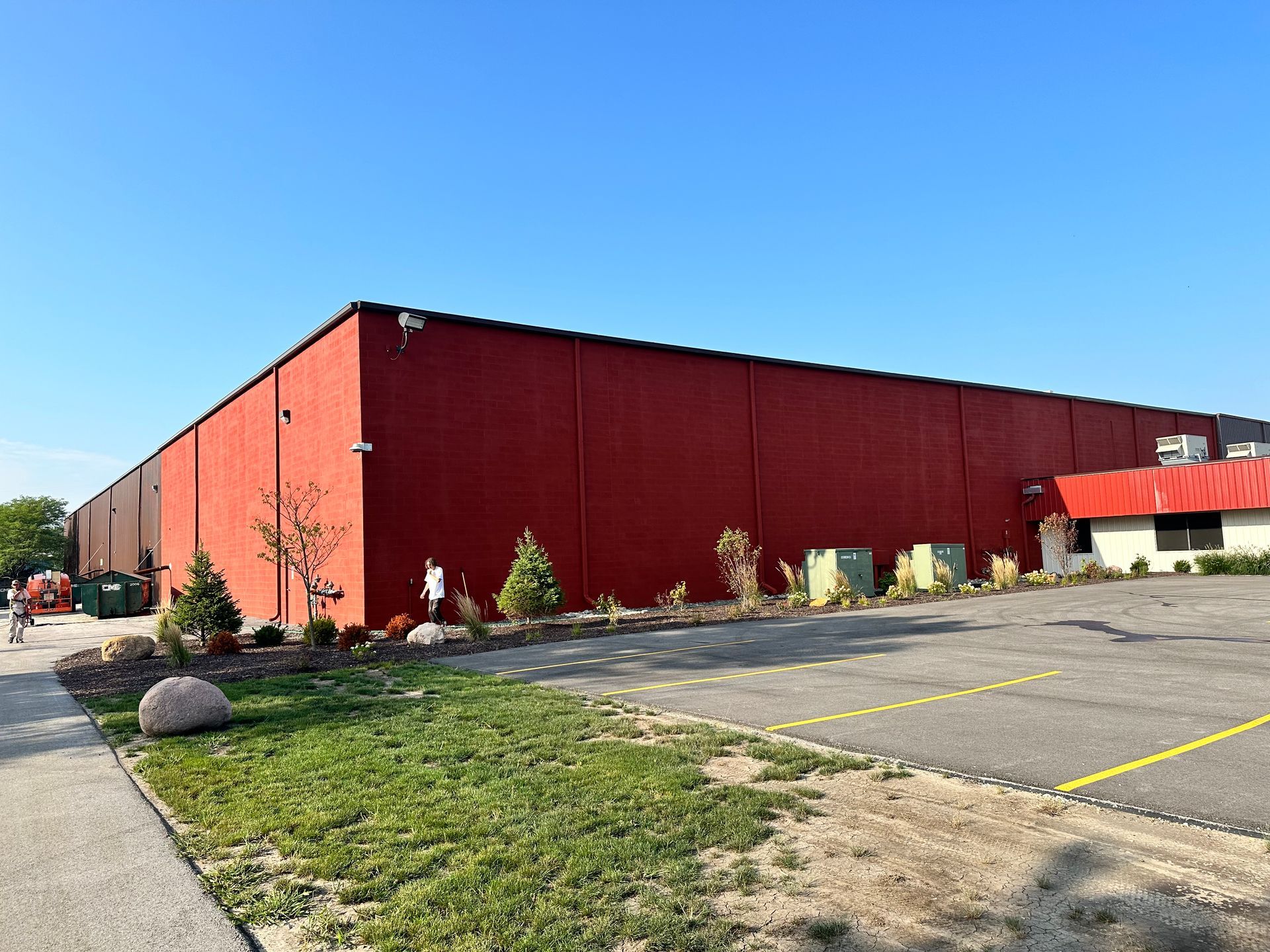 A large red building with a parking lot in front of it.