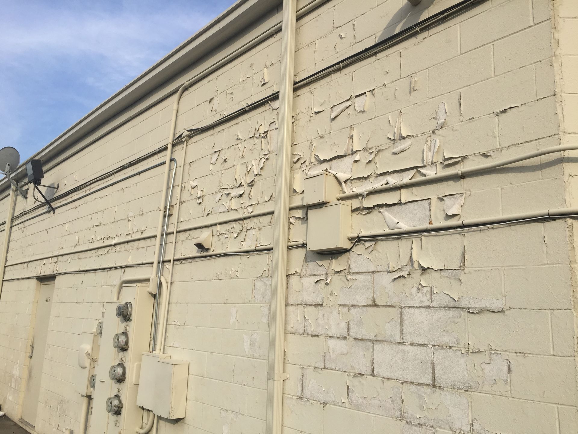 A brick wall with a lot of wires coming out of it