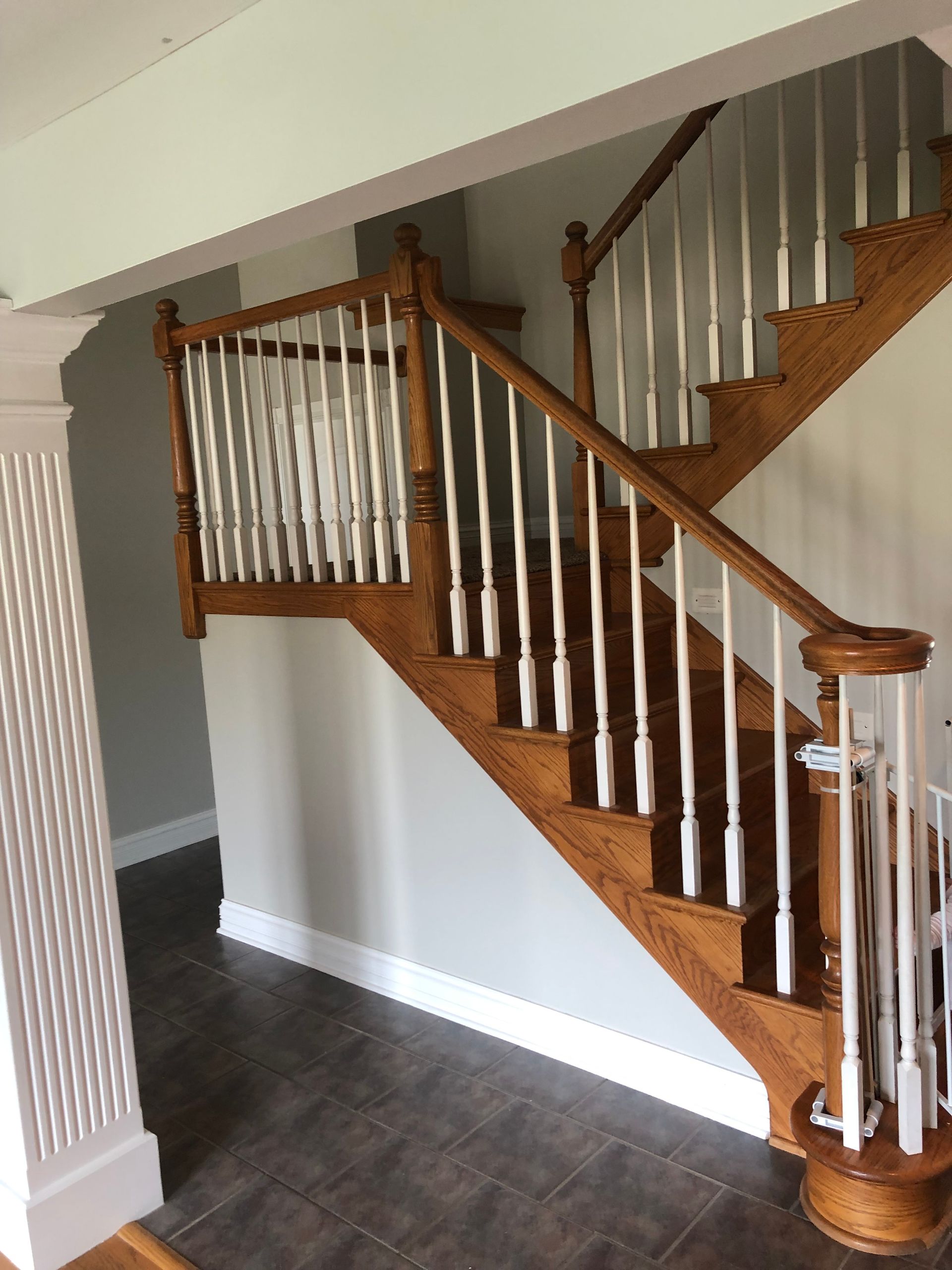 A wooden staircase with white railings in a hallway.