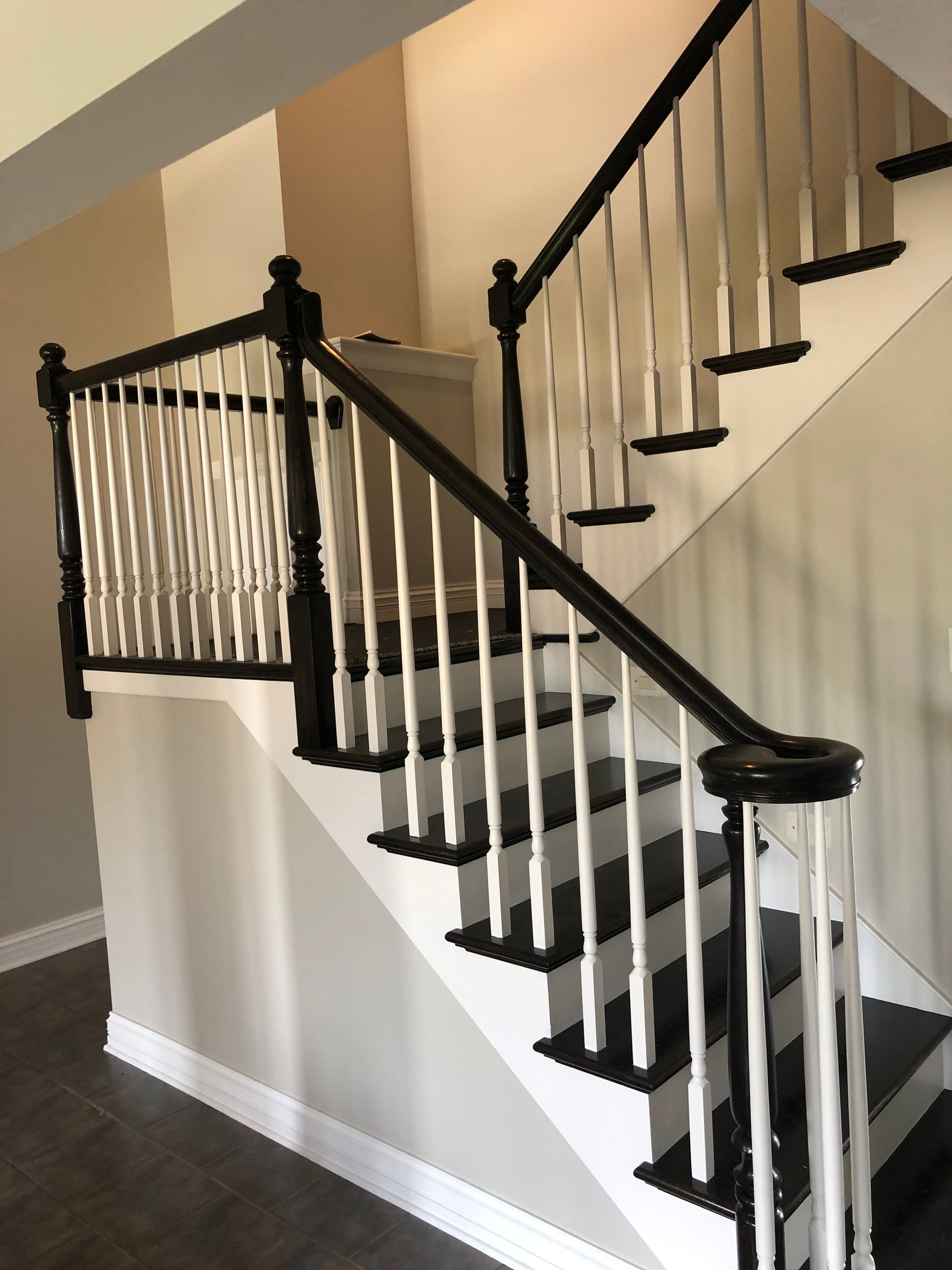 A staircase with a black railing and white steps