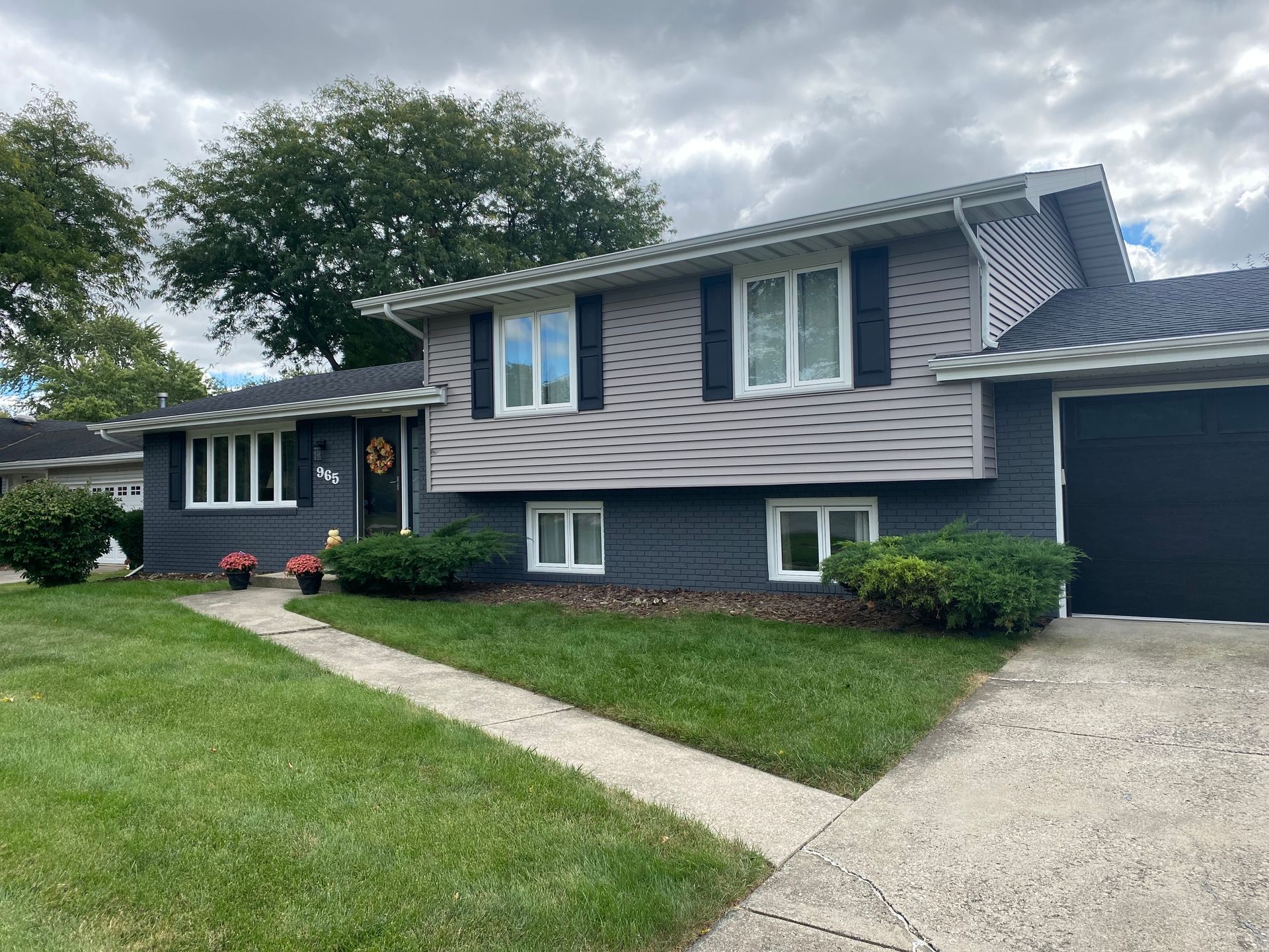 A large house with a lot of windows and a black garage door.