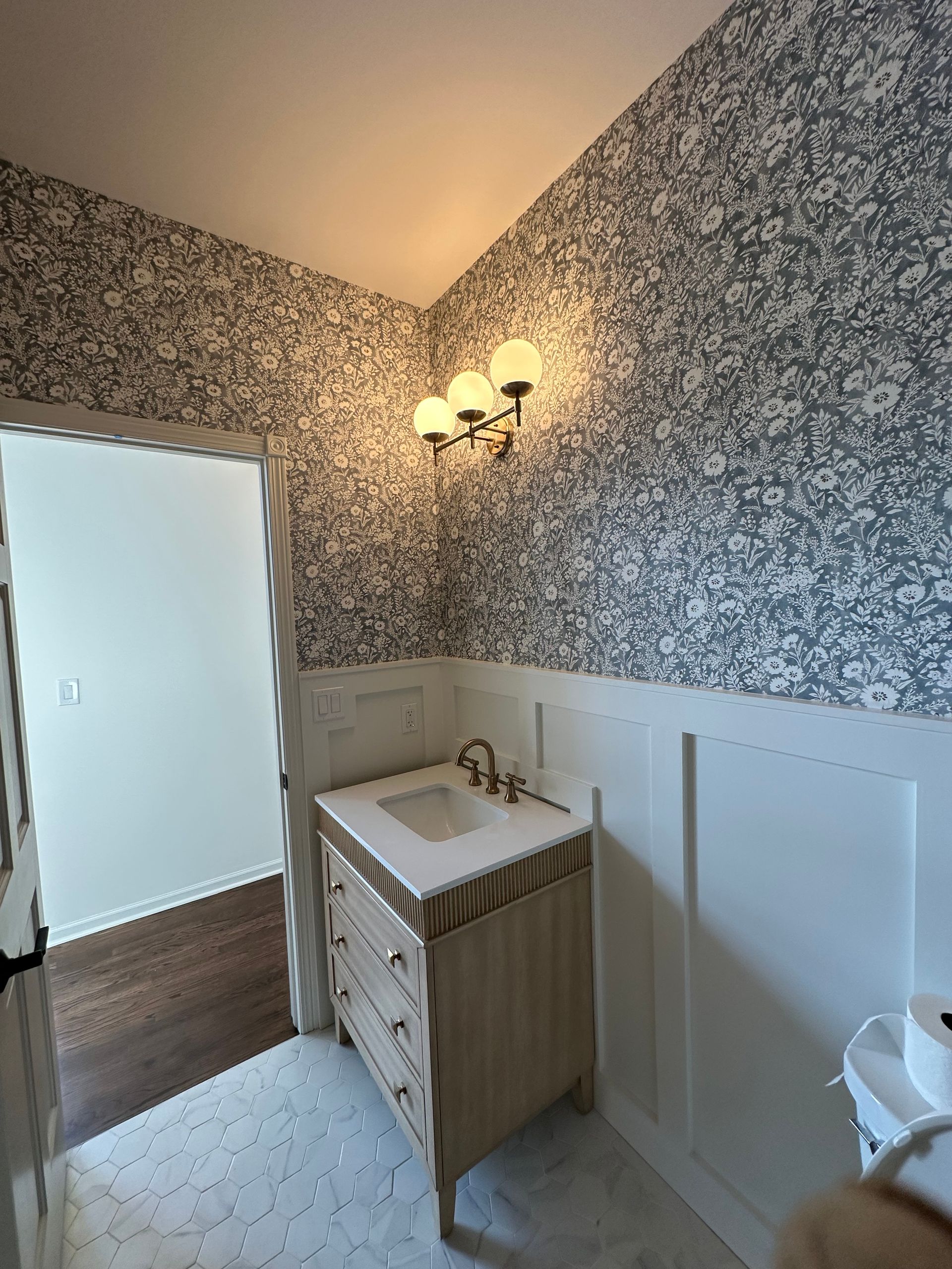 A bathroom with a sink , dresser , and toilet.
