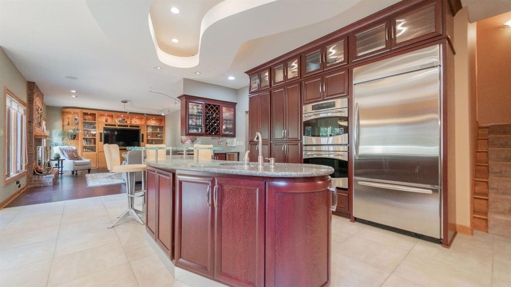 A large kitchen with stainless steel appliances and wooden cabinets.
