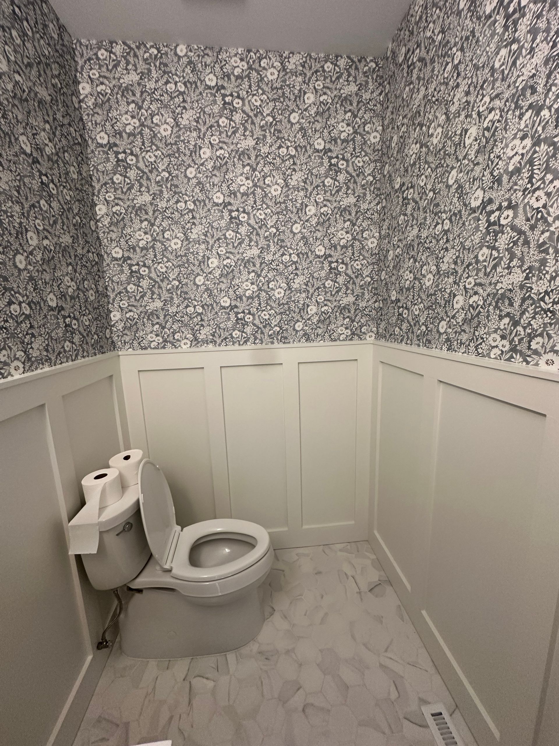 A bathroom with a toilet and a paper towel dispenser.