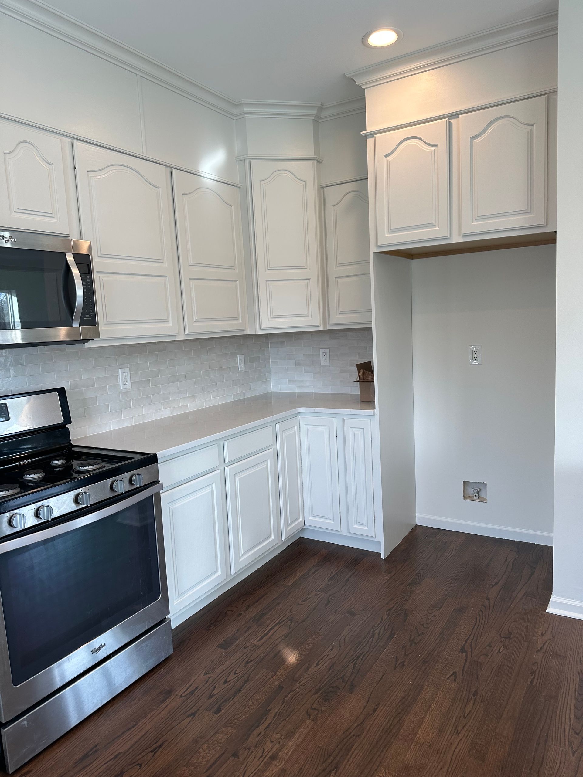 A kitchen with white cabinets and stainless steel appliances