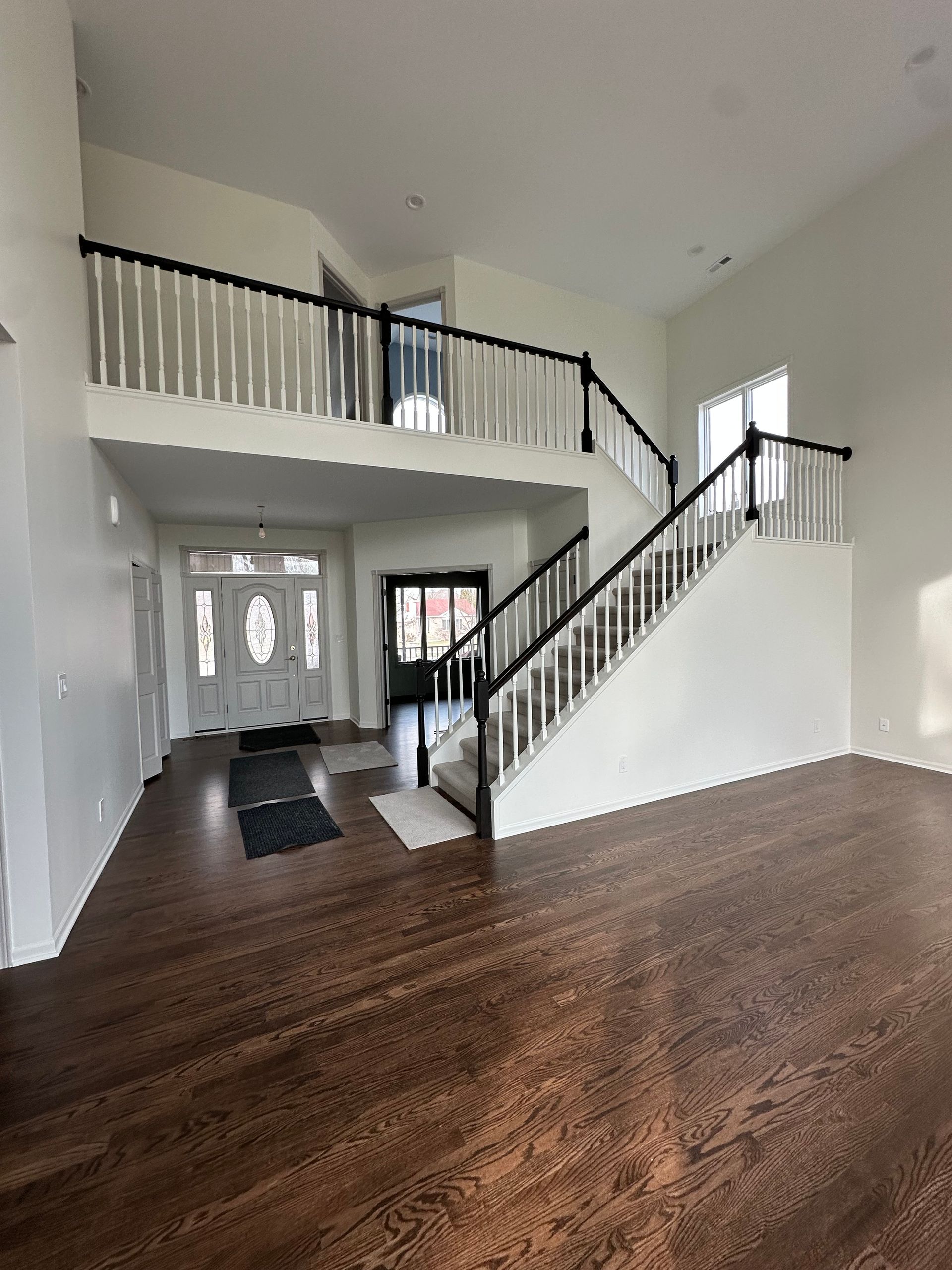 A large empty room with hardwood floors and stairs