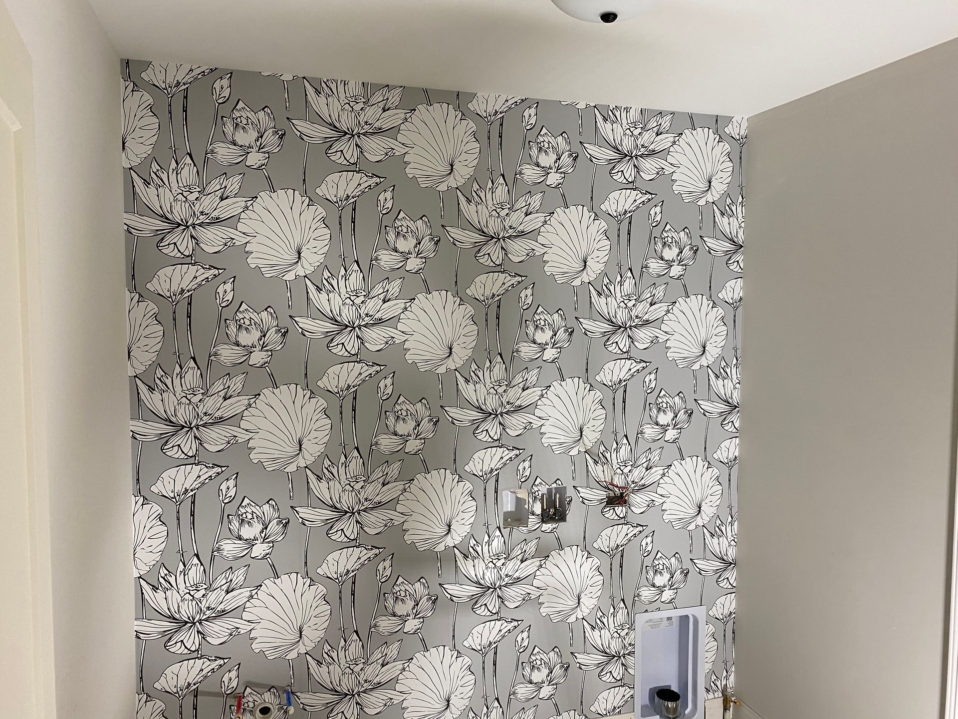 A wall with a pattern of white flowers on it