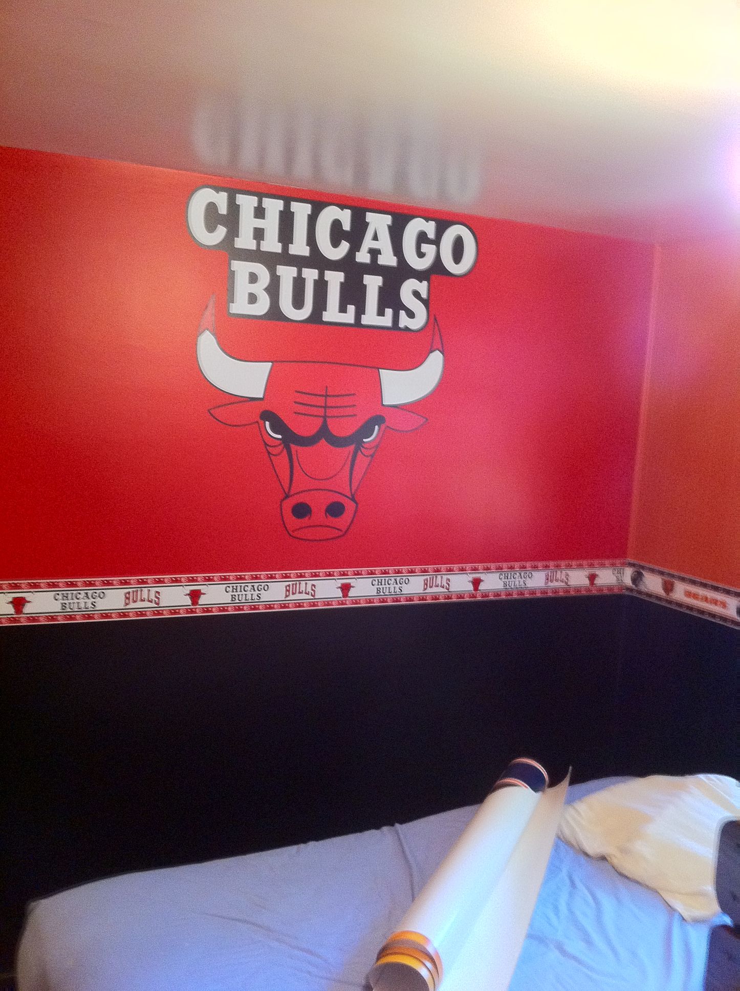 A bedroom with a chicago bulls logo on the wall