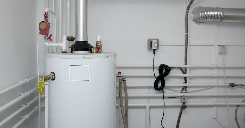 White utility room with a boiler, pipes, valves, and a wall-mounted electrical box