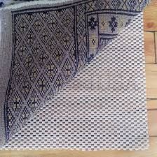 Rug partially lifted, revealing a non-slip pad on a wooden floor.