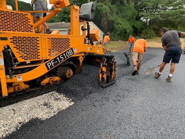 a group of men are working on a road 