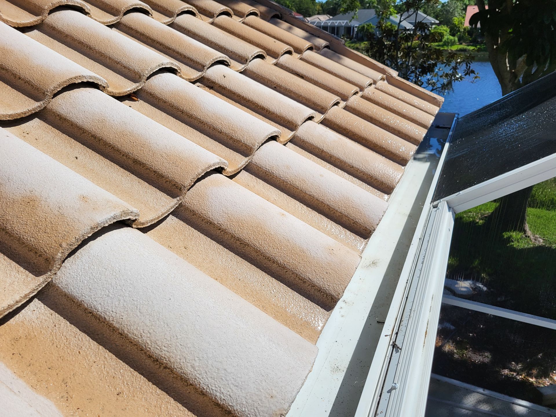 A close up of a tiled roof with a white gutter