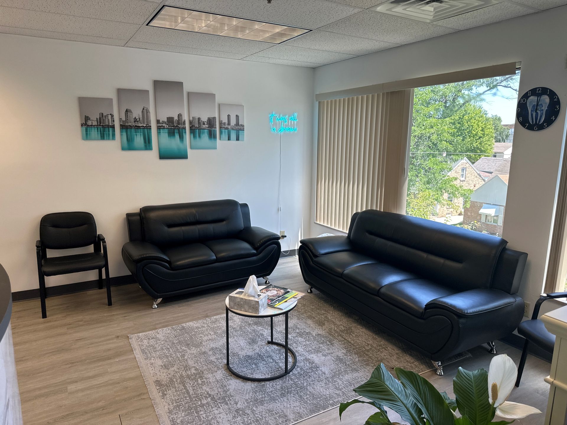 A waiting room with a couch, chairs, and a table.