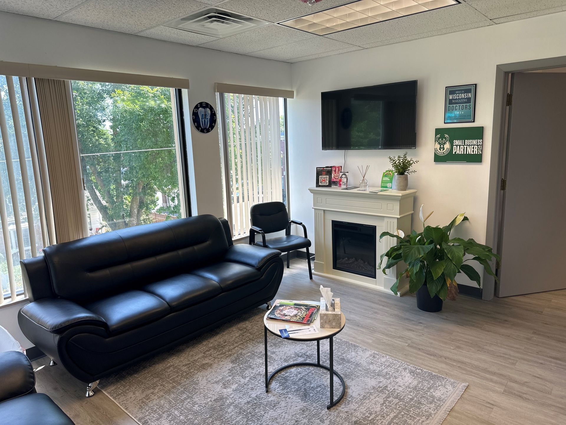 A living room with a couch, table, fireplace, and television.