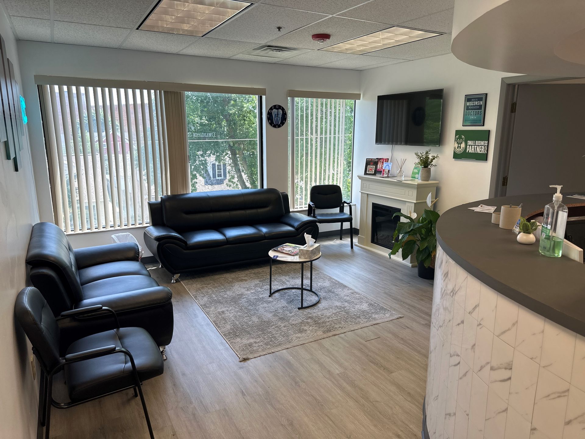 A waiting room with a couch, chairs, and a fireplace.