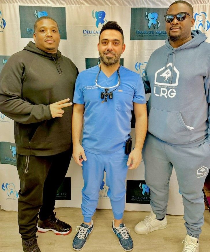 Three men standing next to each other with one wearing a hoodie that says lrg