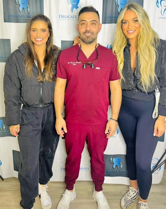 A man in a scrub is standing next to two women.