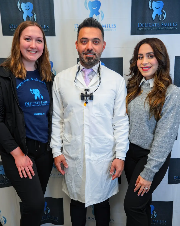 A man in a lab coat is posing for a picture with two women.