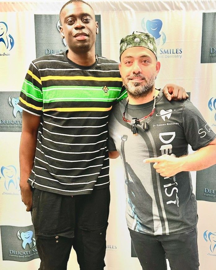 Two men are posing for a picture with one wearing a shirt that says dentist