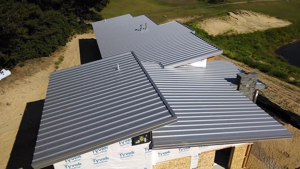An aerial view of a house under construction with a metal roof.