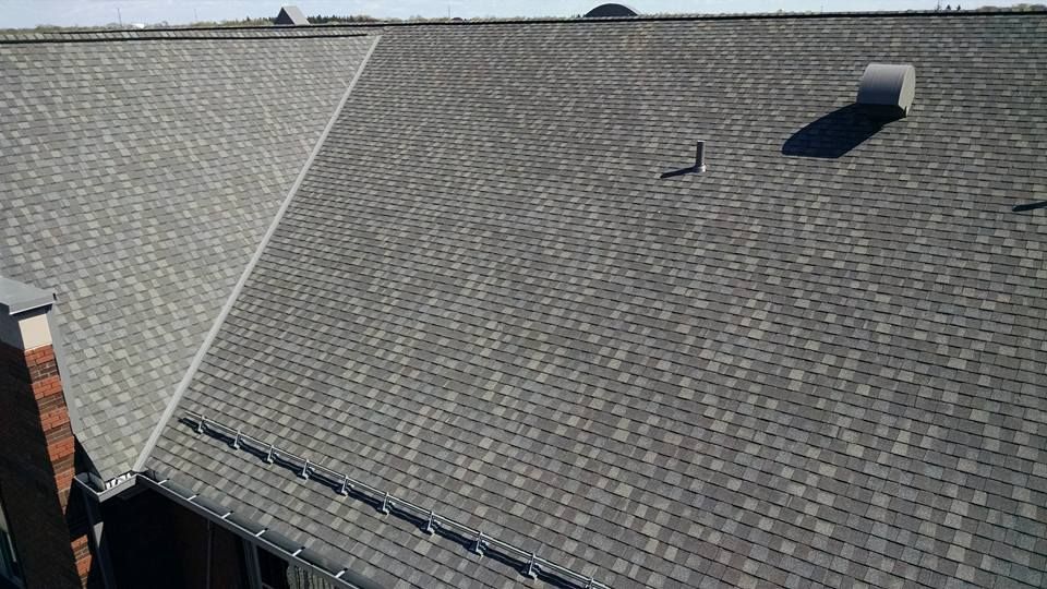 An aerial view of a roof with shingles and a chimney.
