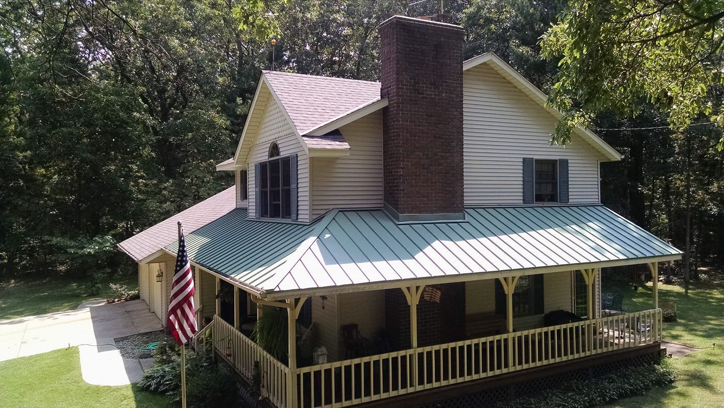 An aerial view of a house with a porch and an american flag