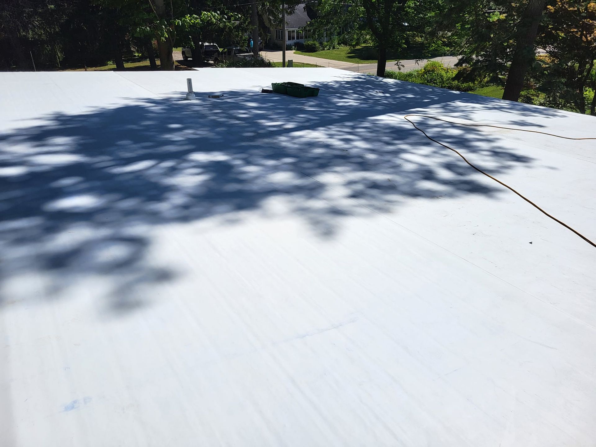 A white roof with a tree shadow on it
