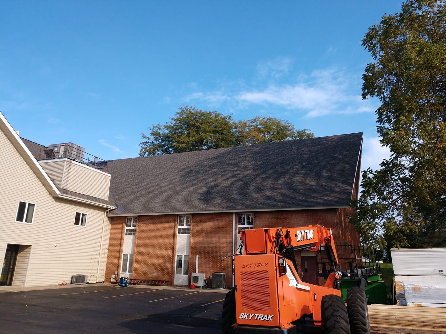 An orange tractor is parked in front of a house