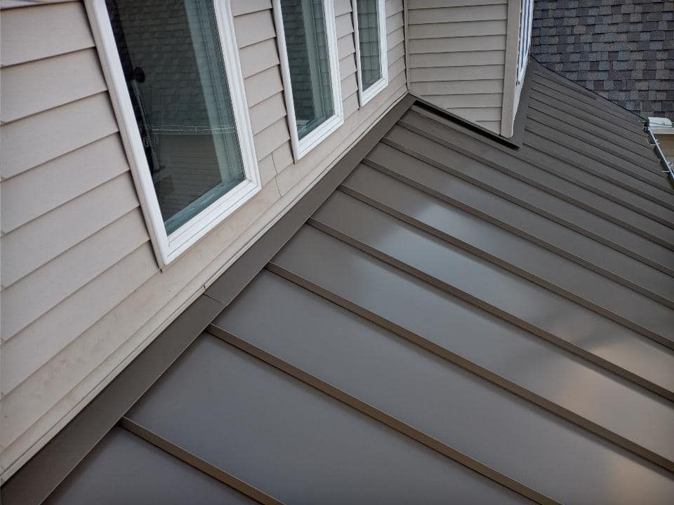 A house with a metal roof and white siding