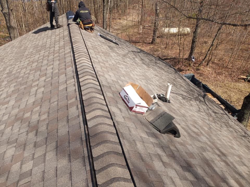 A man is working on the roof of a house.