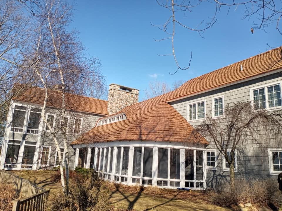 A large house with a screened in porch and a wooden roof.