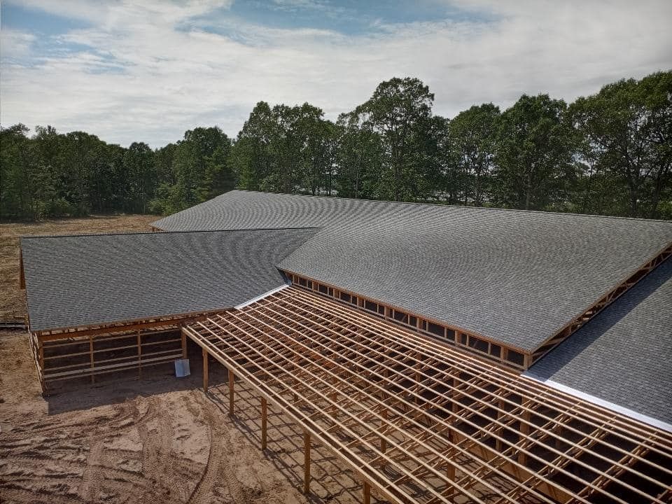An aerial view of a building under construction with trees in the background