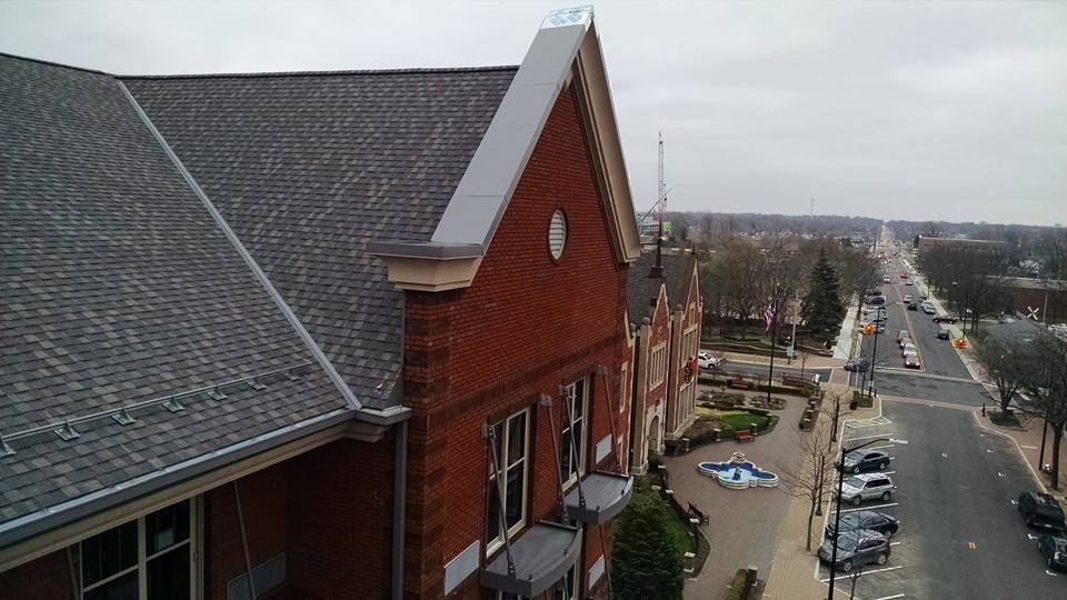 An aerial view of a brick building with a gray roof
