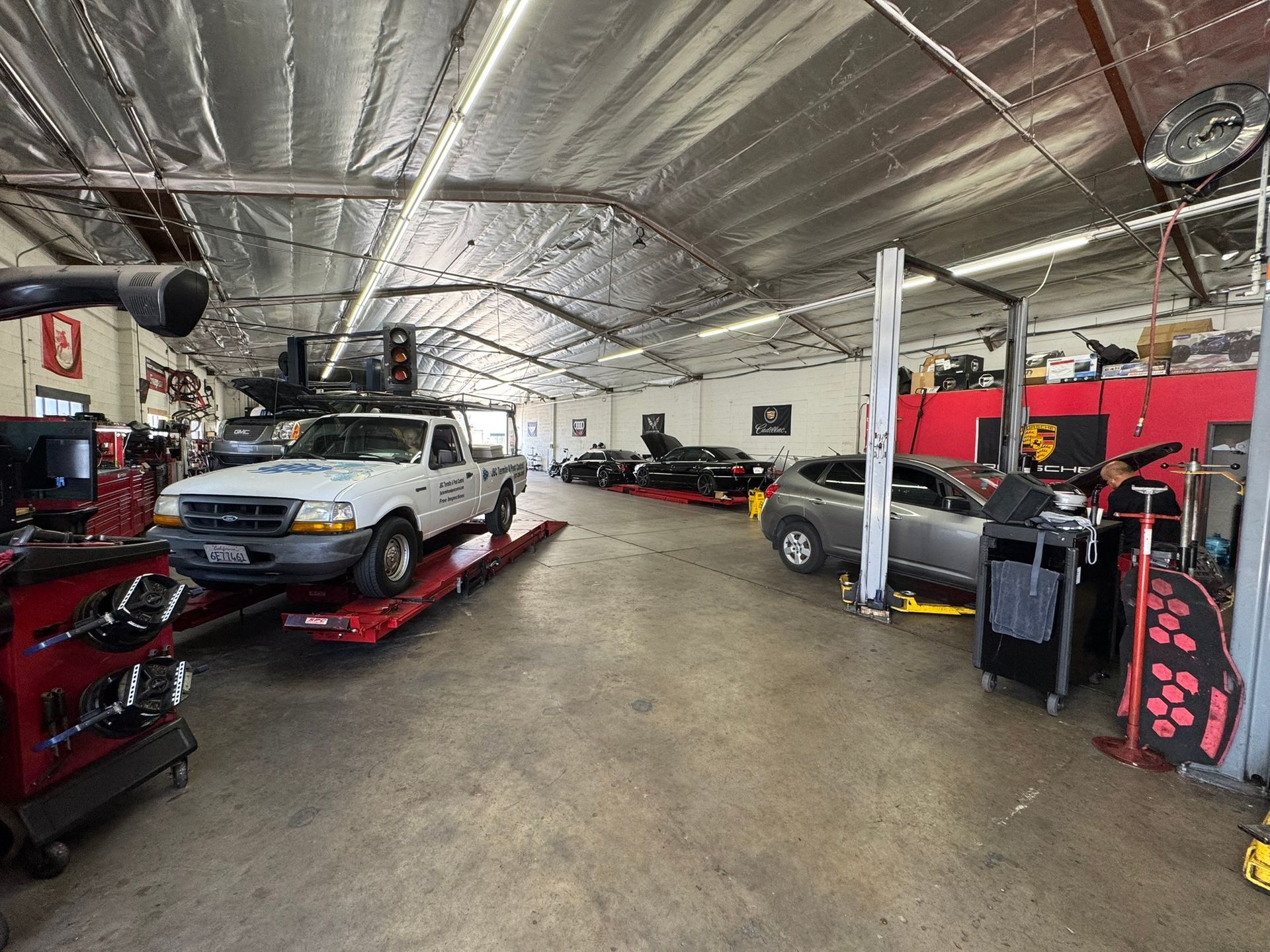 Auto repair shop interior with cars on lifts, tools, and a wide central aisle
