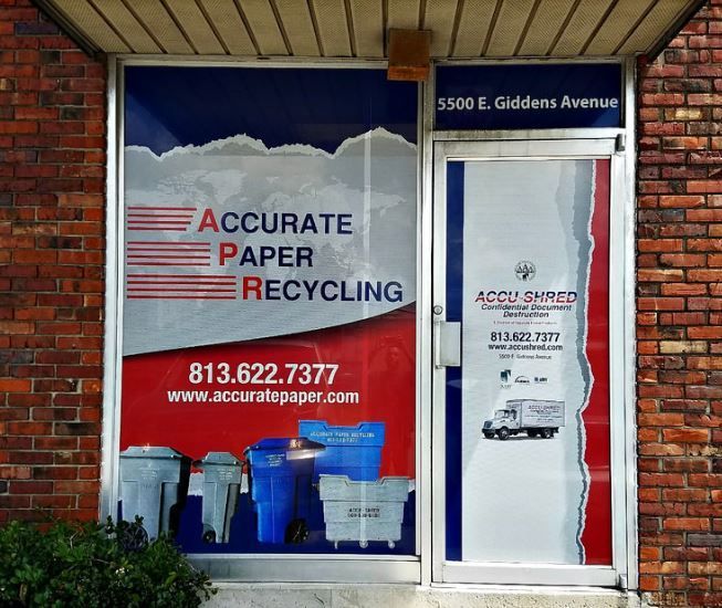 A brick building with a window that says accurate paper recycling
