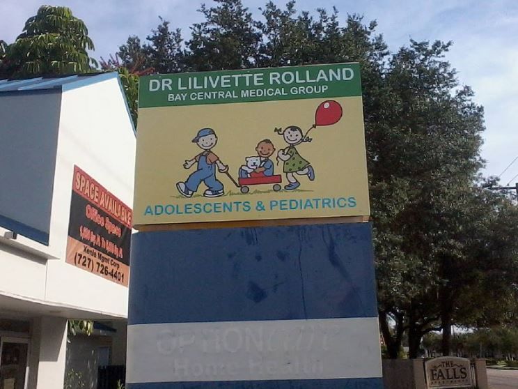 A sign for dr lilivette rolland shows a boy pushing a wagon with a girl holding a balloon