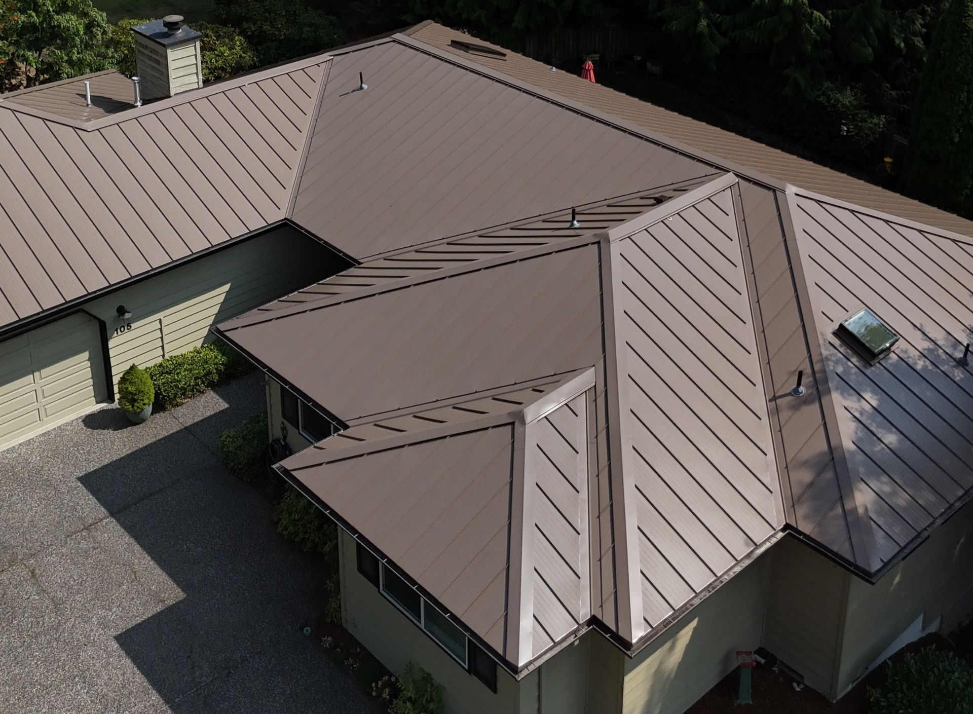 Brown metal roof on a residential home; multiple roof planes and chimney.