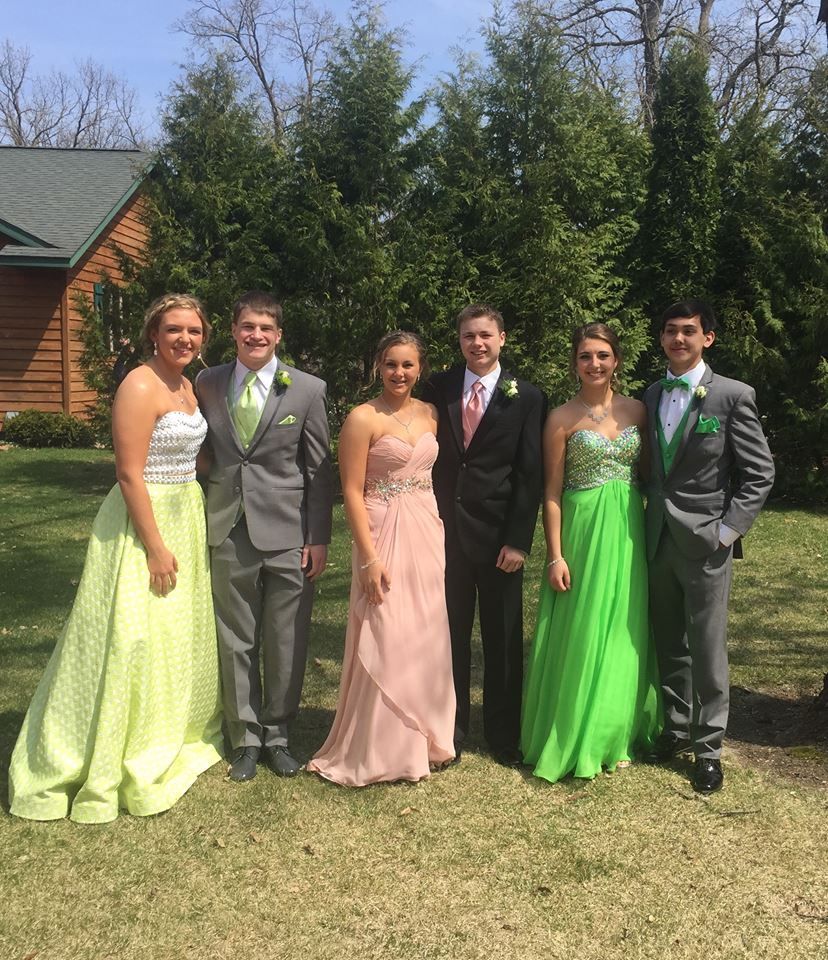 A group of people are posing for a picture in front of a house.