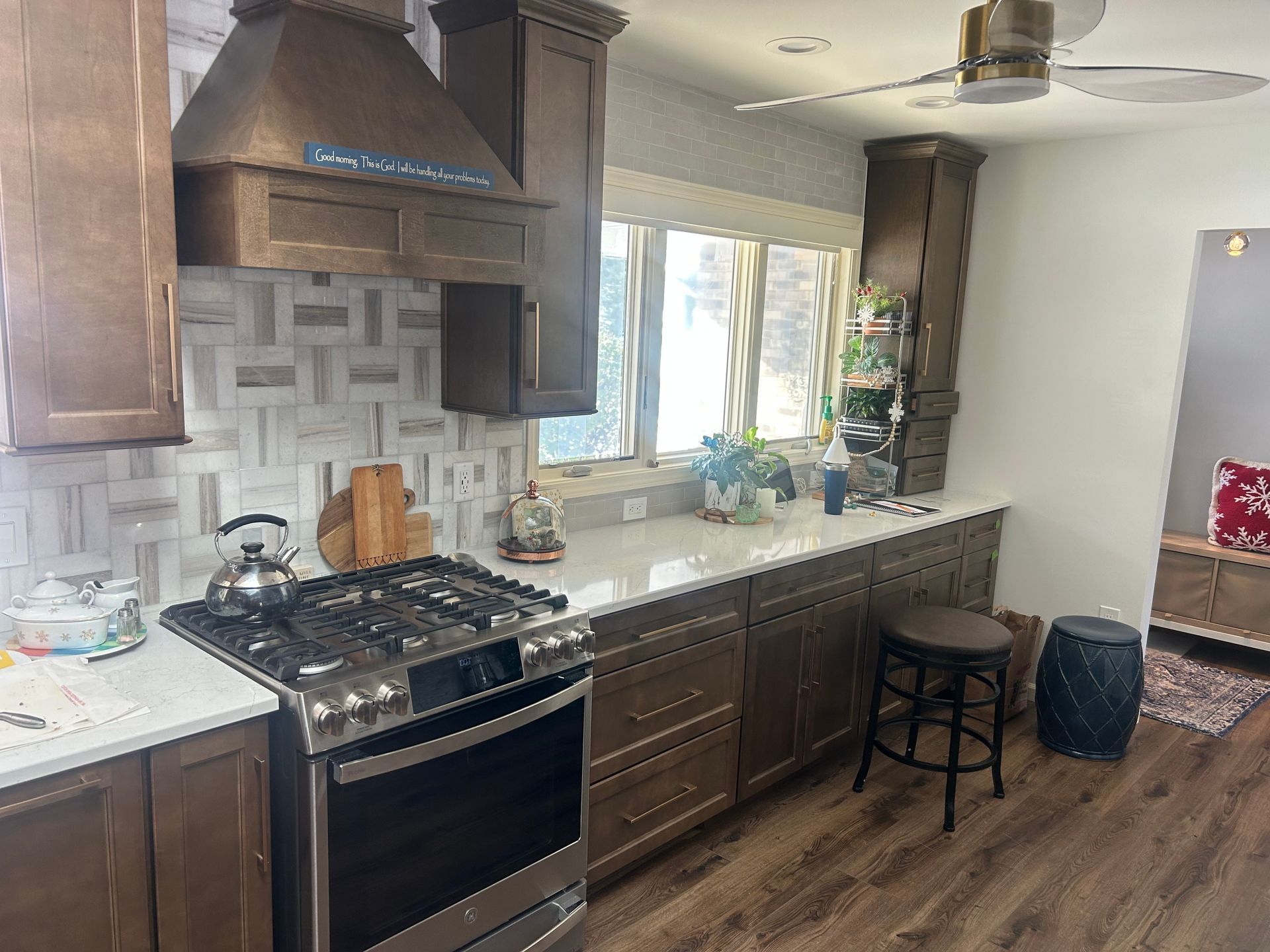 After - Kitchen with brown cabinets, stainless steel appliances, and white countertops.