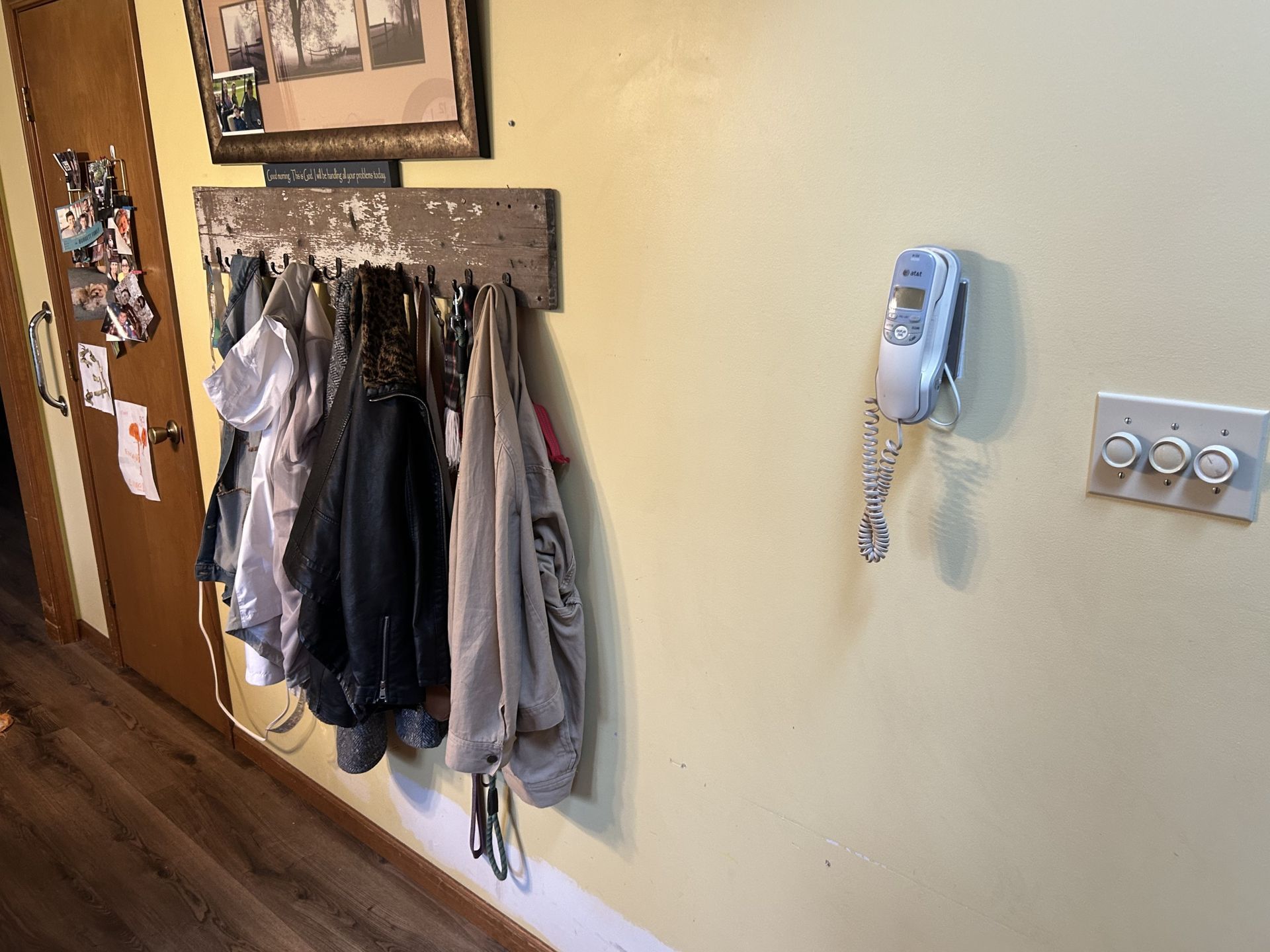 Before - A wall with a coat rack, phone, and light switches. Coats hang on the rack.