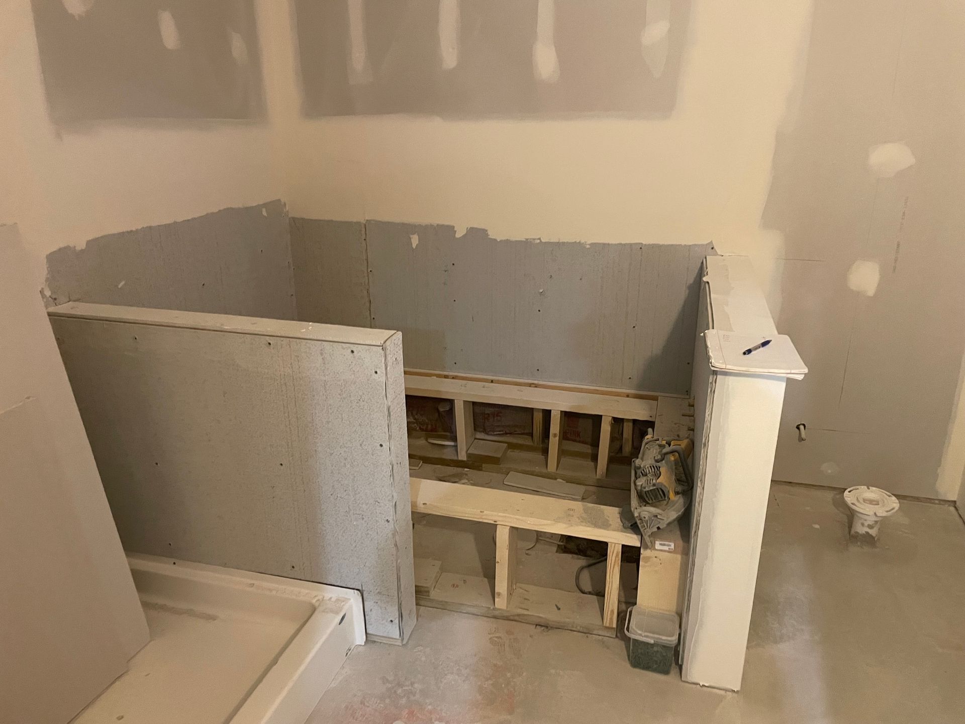 Bathroom in renovation. Unfinished walls surround a wooden structure.