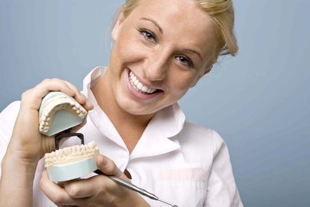 A woman is holding a clear brace in her mouth and smiling.